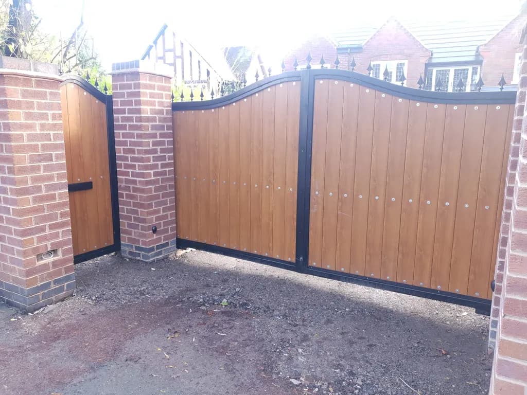 Arched timber-clad gates hung on newly built brick piers