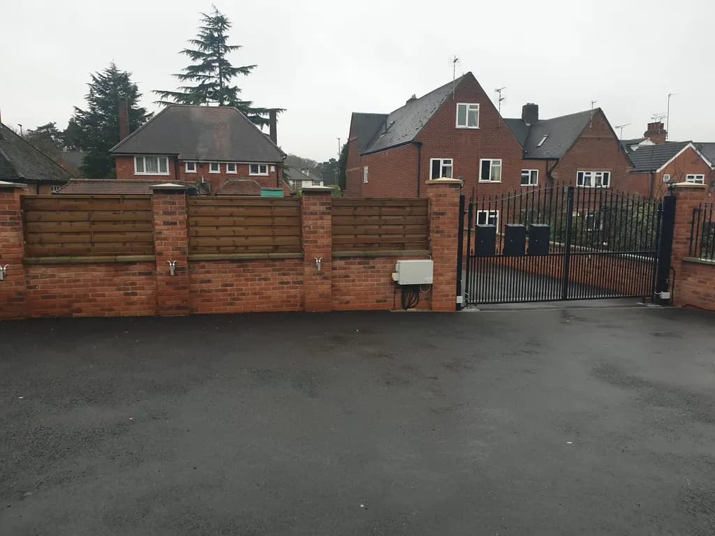 Bar gates and brick wall frontage to a private driveway