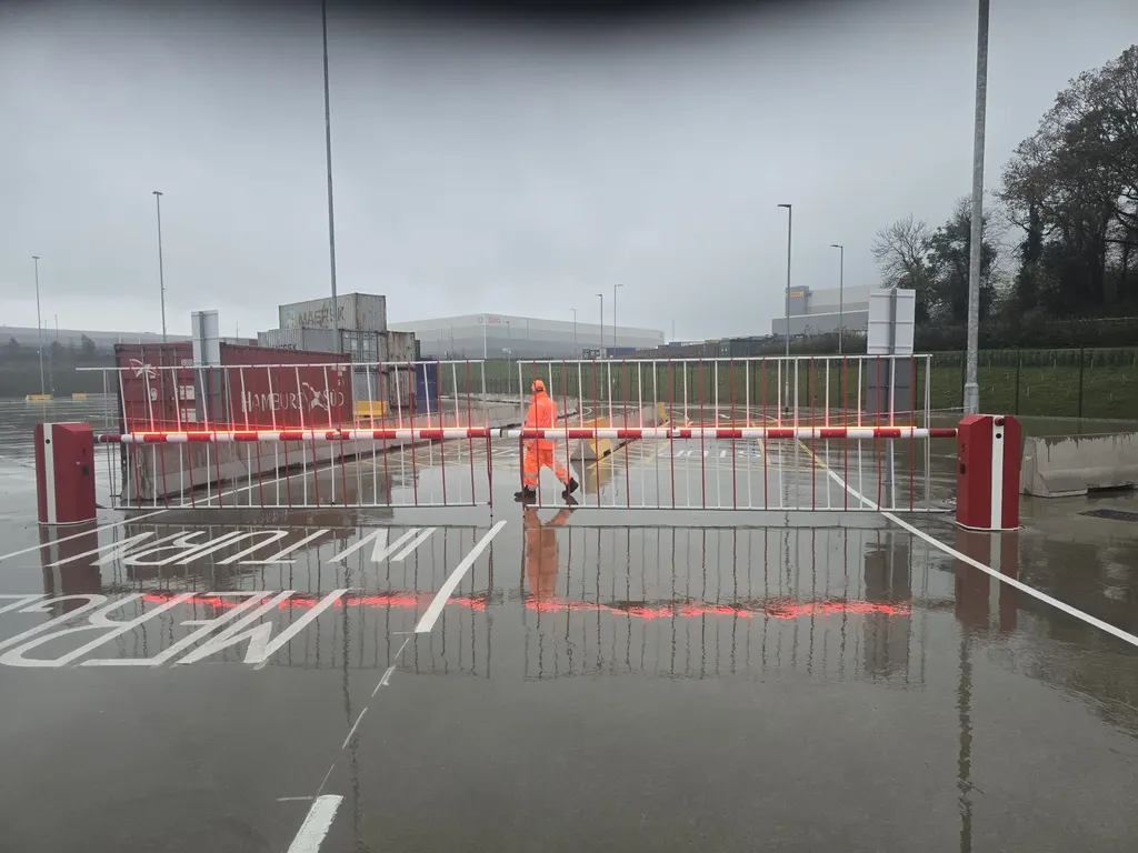 Rising-arm barriers controlling entry and exit lanes at a container yard