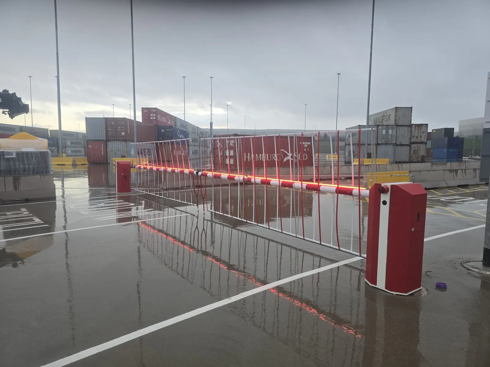 Barrier-controlled lanes at a container storage yard after rain