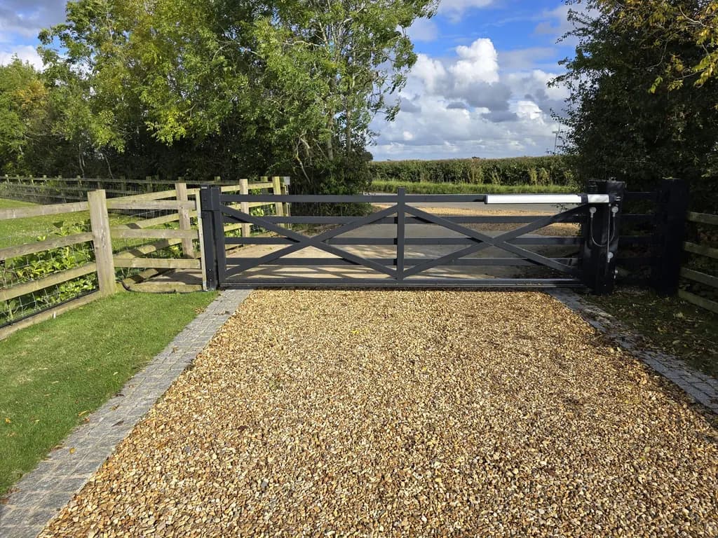 Timber five-bar gate automated on a gravel country driveway