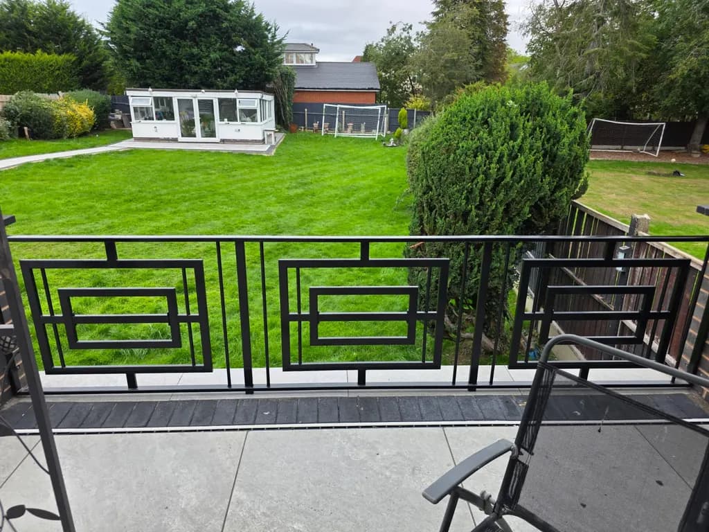 Metal railings and balustrade bordering a lawn and patio
