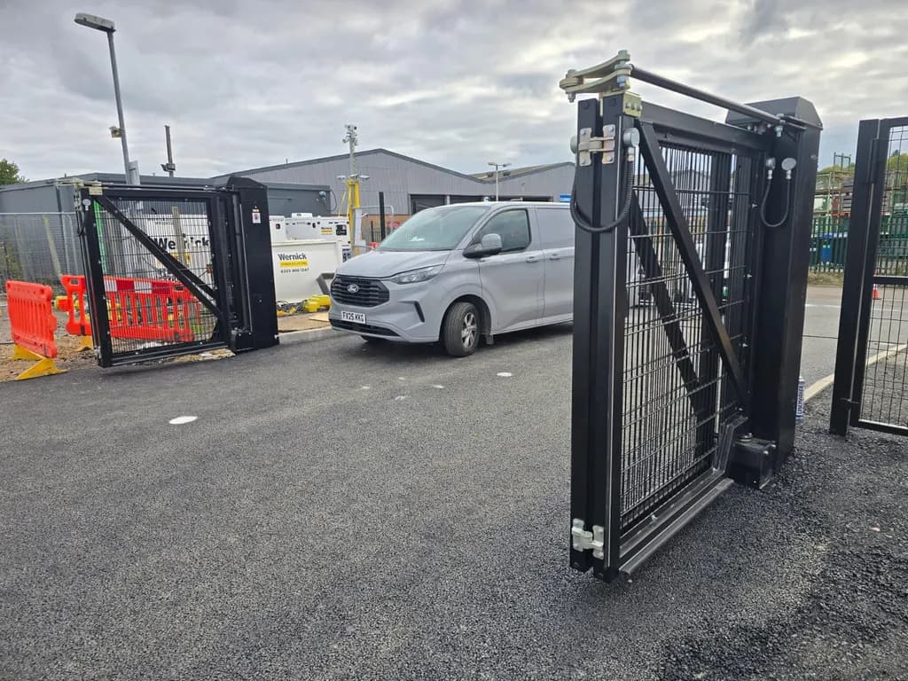 New bi-folding gate being installed at a commercial yard entrance