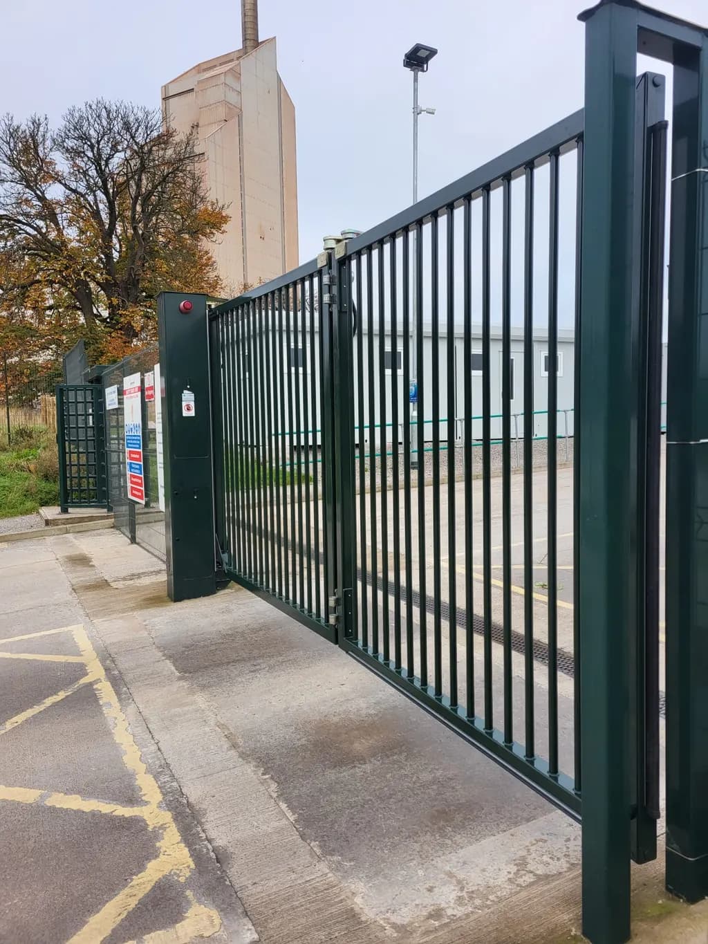 Green mesh sliding gate at a commercial car park entrance