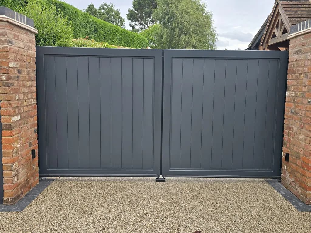 Grey panelled automated swing gates closing a private drive