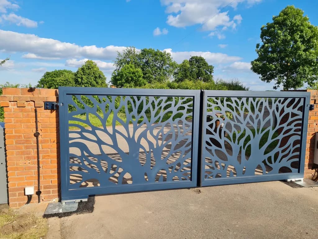 Laser-cut steel gates standing open across a driveway