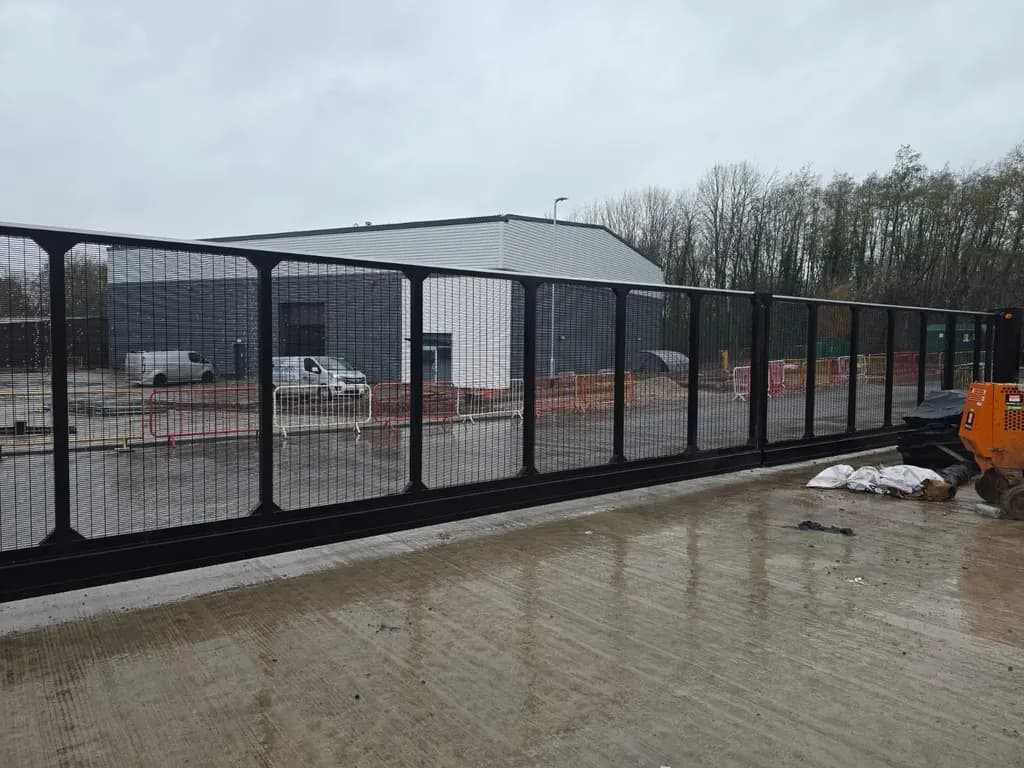 Long mesh sliding gate spanning a wide yard entrance