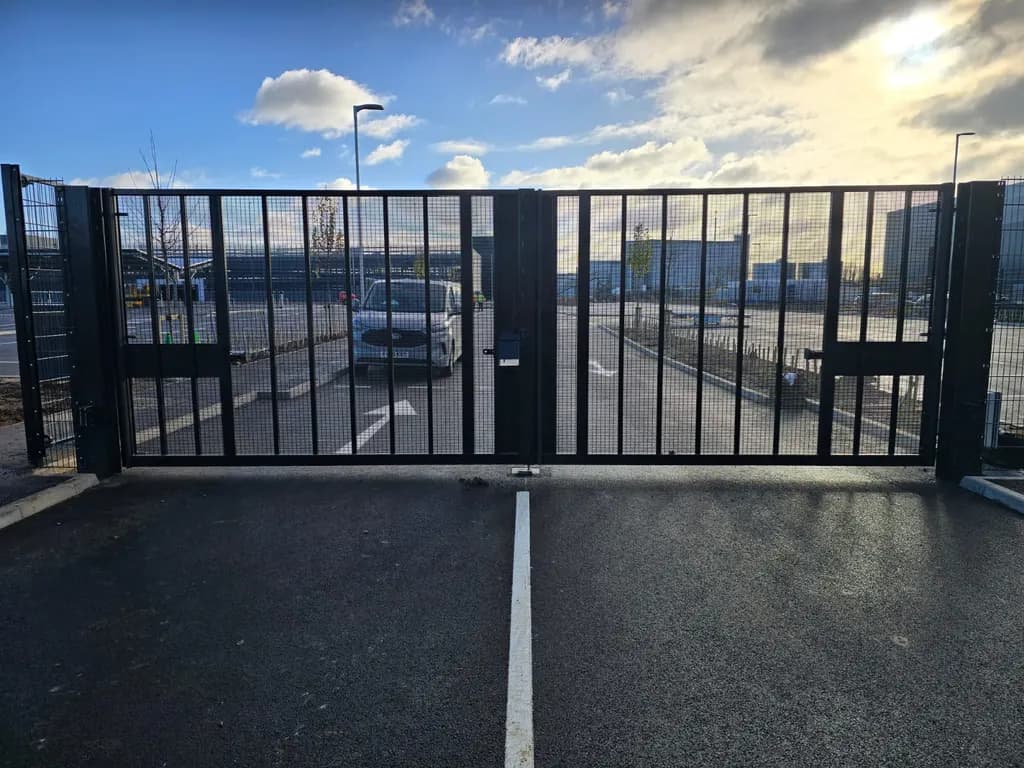 Tall mesh double gates closing an industrial estate road