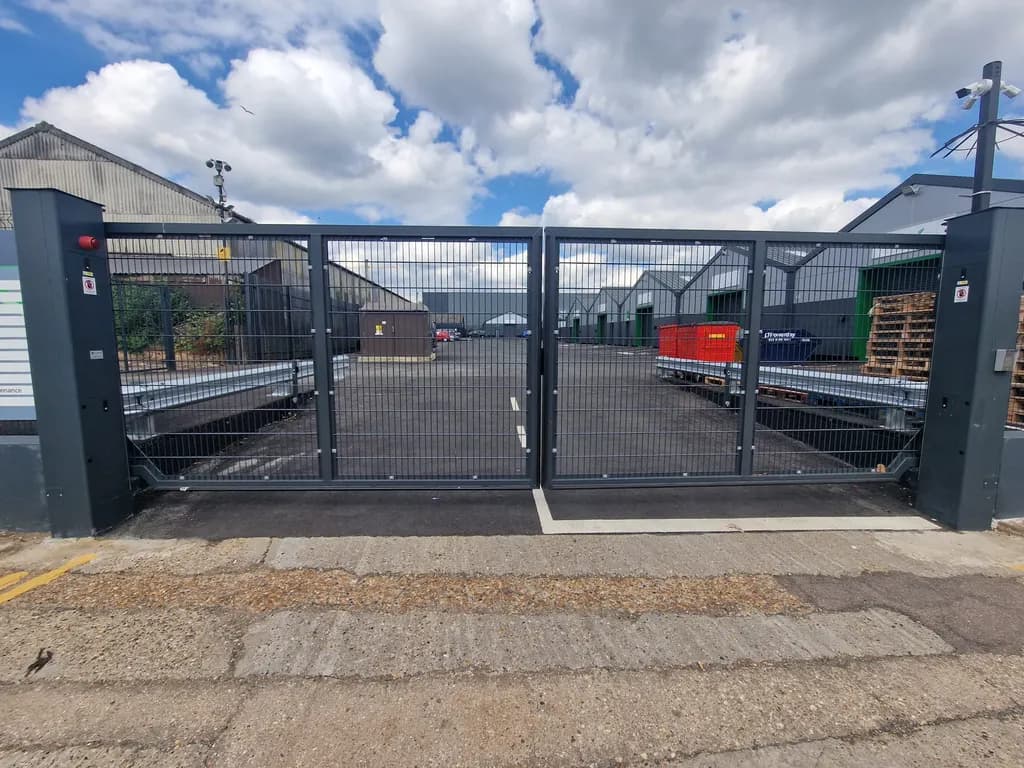 Mesh gates and operator column at the entrance to a builders yard