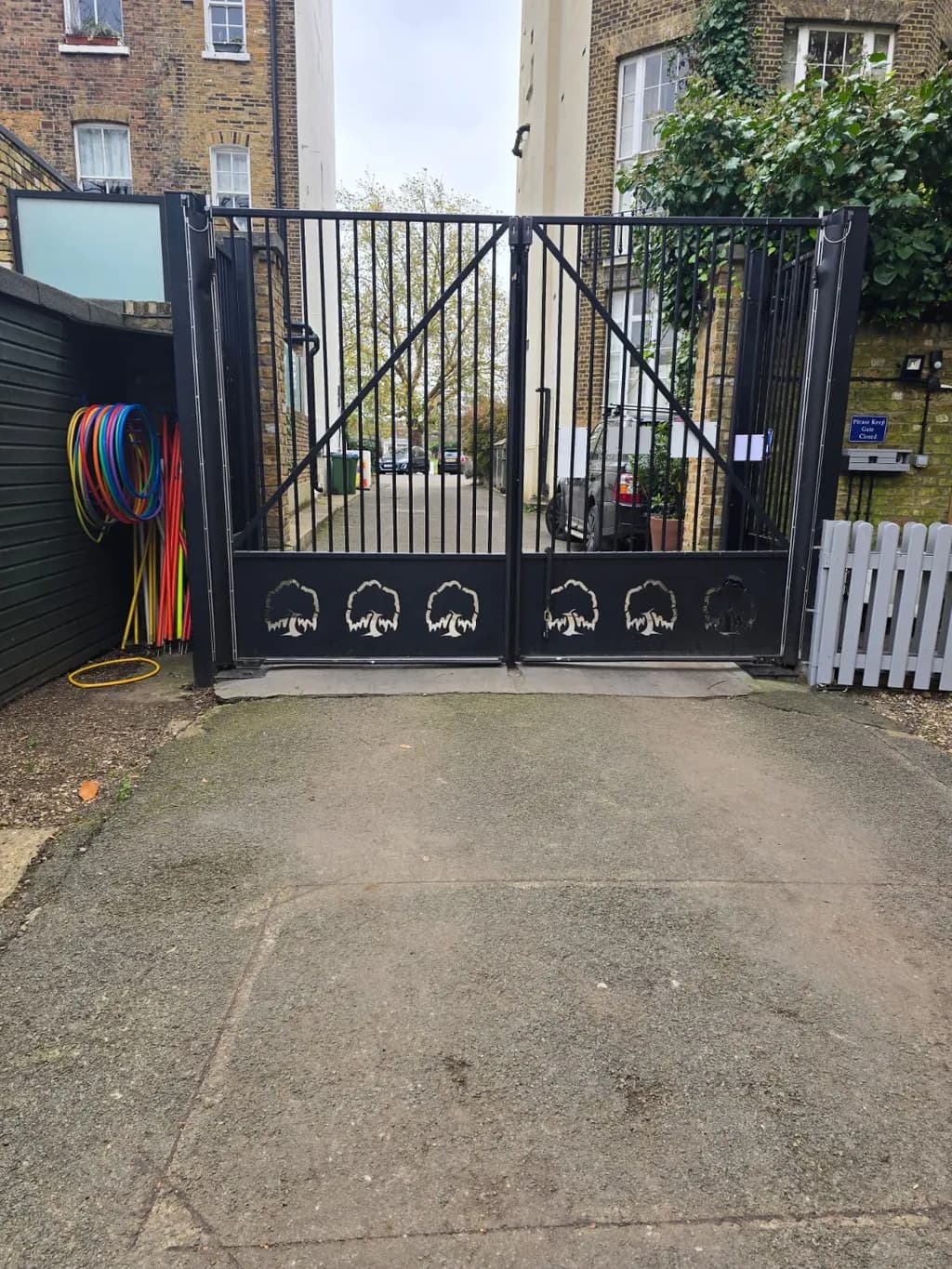Ornamental metal gates automated on a narrow entrance between buildings