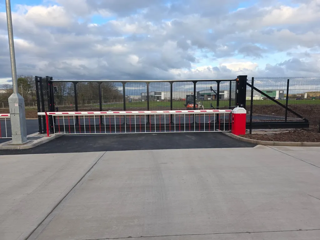 Rising-arm barrier and mesh fencing at a controlled site entrance