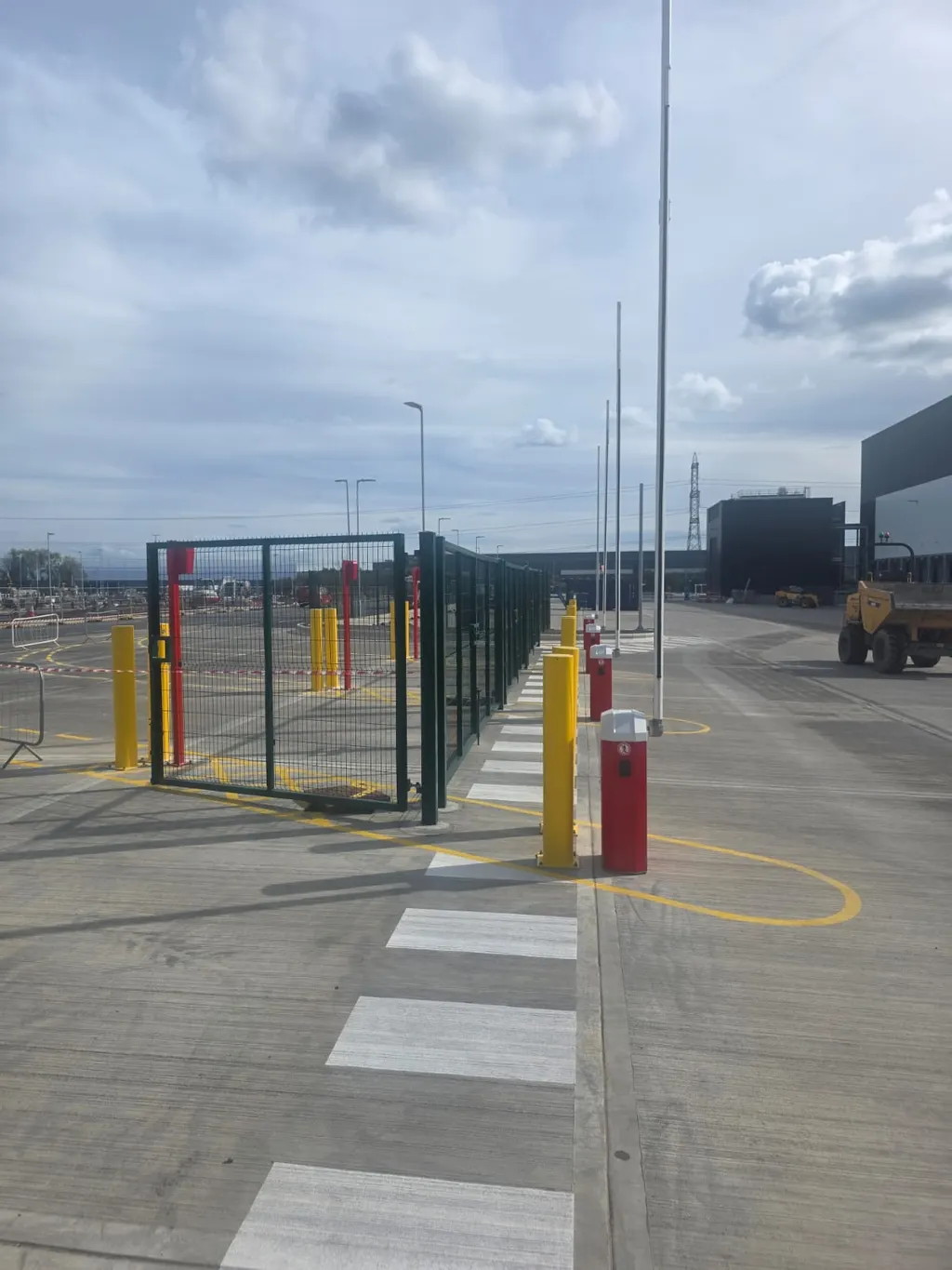 Yellow security bollards protecting an industrial access point