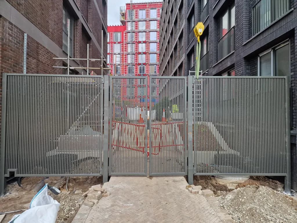 Mesh gates set into site hoarding at a construction entrance