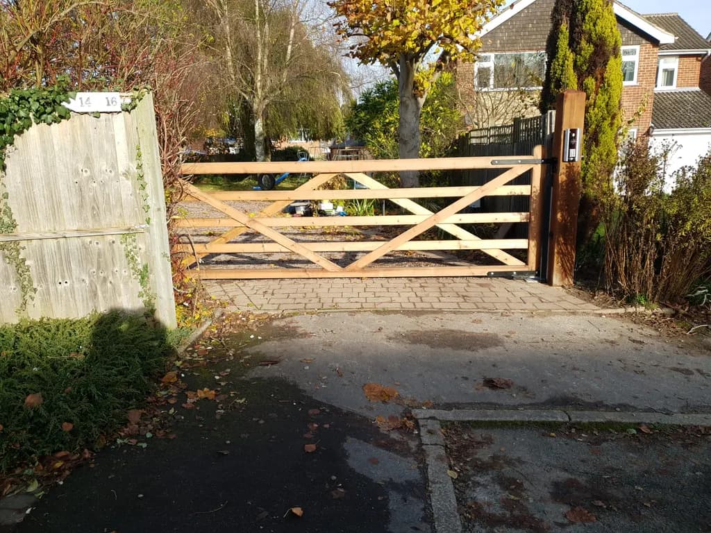 Timber five-bar gate automated across a suburban driveway