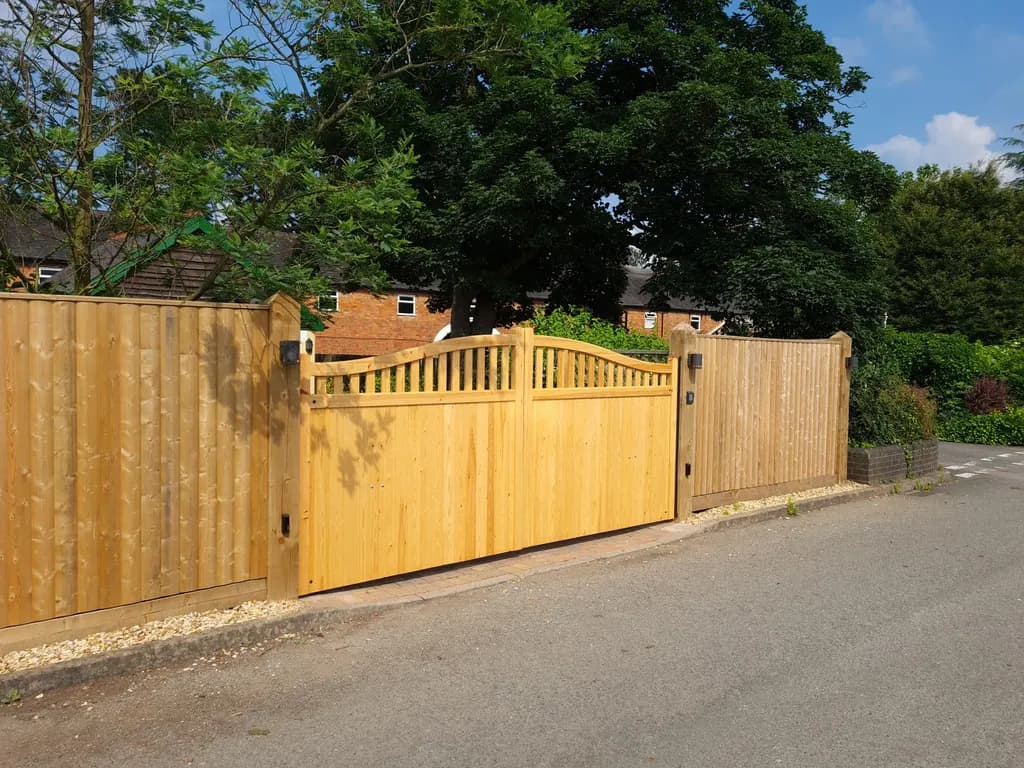 Timber gates and matching boundary fencing across a driveway entrance