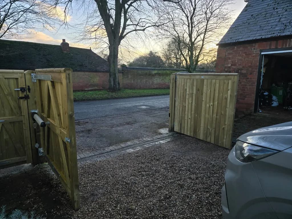 Timber swing gates standing open at a farm entrance
