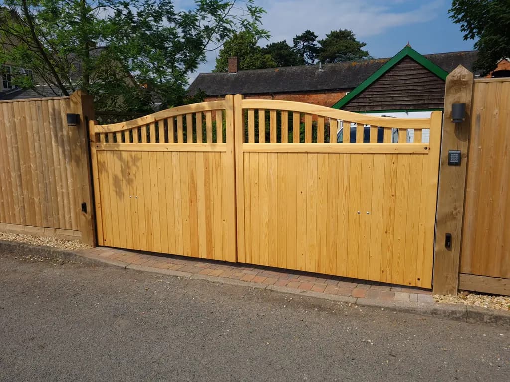 Curved-top timber gates at a village property, seen from the road