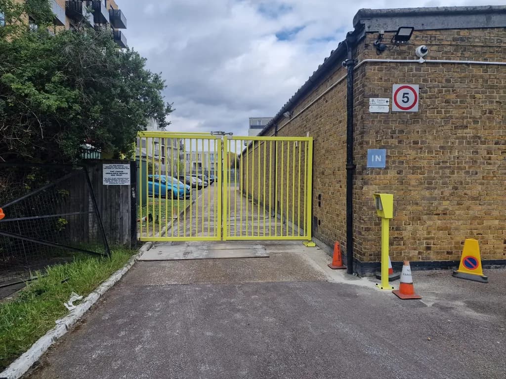 Yellow bar gates on a service access road between buildings